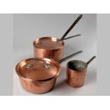 A GROUP OF THREE COPPER SAUCE PANS, with lids and iron handles, of various constructions, 62cm