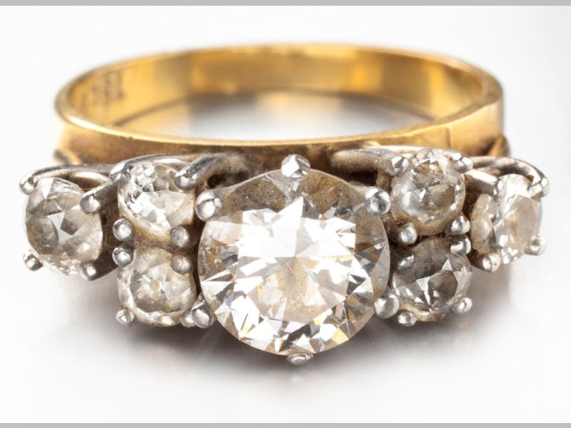 AN 18ct YELLOW GOLD AND DIAMOND RING, centre round brilliant cut diamond flanked by three claw set
