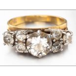 AN 18ct YELLOW GOLD AND DIAMOND RING, centre round brilliant cut diamond flanked by three claw set