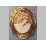 A 9ct YELLOW GOLD CAMEO BROOCH, depicting the face of a classical maiden, in an oval scroll frame,