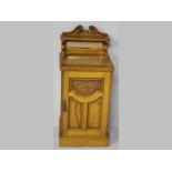 AN EDWARDIAN WALNUT AND OAK PEDESTAL, the rectangular top with a shelf and broken arch pediment