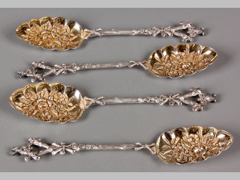 A SET OF FOUR SILVERPLATE BERRY SPOONS, handles realistically moulded in the form of a branch