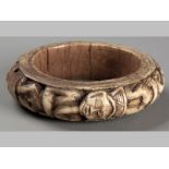 AN EARLY 20TH CENTURY AFRICAN CARVED IVORY ARM BANGLE, of cylindrical form, depicting carved African