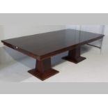 A PIERRE CRONJE MAHOGANY DINING TABLE, the rectangular stepped top supported on a pair of faceted