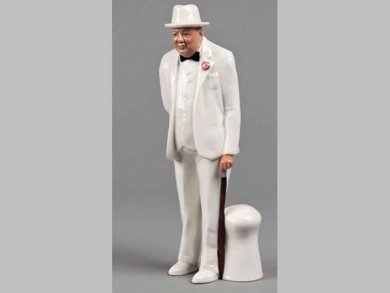 A ROYAL DOULTON "SIR WINSTON CHURCHILL" FIGURINE, dressed in a white suit holding a cane, base