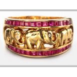 AN 18ct YELLOW GOLD AND RUBY RING, centre of ring decorated with elephant motifs, flanked by two