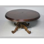 A VICTORIAN OAK CIRCULAR DINING TABLE, the segmented top with a triple moulding standing on a