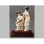 AN EARLY 20TH CENTURY CHINESE IVORY CARVING OF TWO FEMALE MUSICIANS, standing on a silver-wire