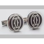 A PAIR OF SILVER AND BLACK LACQUER CARTIER CUFFLINKS, of oval form with double Cartier logo, 20.5 by