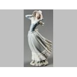 A BISQUE LLADRO FIGURE OF A YOUNG LADY, on a windy day, in period costume, base bearing factory