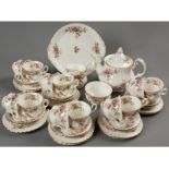 A ROYAL ALBERT TEA SERVICE IN THE MOSS ROSE DESIGN, comprising: a teapot, creamer, sugar basin, cake