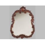 A 19th CENTURY GERMAN OAK MIRROR, the serpentine frame with profusely carved foliage, flowers and