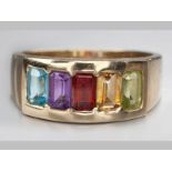 A 9ct YELLOW GOLD, MULTI STONE RING, five natural stones in channel setting ending in a solid shank,