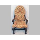 AN OAK ARMCHAIR, upholstered in needlework style fabric, the scrolled arms with acanthus leaf