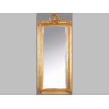 A GILT FRAMED RECTANGULAR MIRROR, the top-rail surmounted by carved foliage and a bird, the