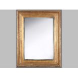 A GILT FRAMED RETANGULAR MIRROR, the moulded rectangular frame with a gilt slip and bevelled glass