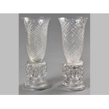 A PAIR OF ENGLISH CUT GLASS TABLE CENTRE PIECES, the fluted vase tops with diamond shape cutting,