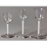 A GROUP OF THREE AIR TWIST STEM GLASSES, probably late 18th Century English, chips to feet, 15cm