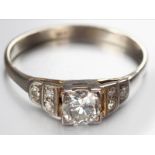 AN 18CT WHITE GOLD AND DIAMOND RING, centre diamond claw set, flanked by two diamonds ending on a