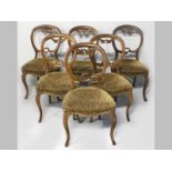 A SET OF SIX VICTORIAN MAHOGANY DINING CHAIRS, the hooped backs with carved floral decoration, the