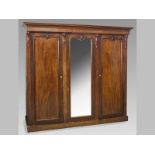 A VICTORIAN MAHOGANY TRIPLE DOOR WARDROBE, the moulded cornice above a mirrored central door with