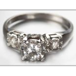 AN 18CT WHITE GOLD AND DIAMOND RING, a brilliant claw set diamond with raised stepped shoulders