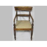A REGENCY MAHOGANY CARVER CHAIR, the broad arched top-rail above reeded arms and upholstered let-