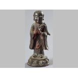 A CHINESE BRONZE FIGURE OF A MONK - 17TH/18TH CENTURY, monk at prayer standing on a lotus flower,