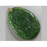 A JADEITE PENDANT, oval form, carved with kylin in scrolls, reverse depicting a bird in landscape, 6