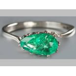 AN 18CT WHITE GOLD AND EMERALD RING, pear shaped emerald claw-set, on a solid band, 2.9g.
