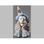 A LLADRÓ FIGURINE OF A CLOWN, resting his face in his hands, base with printed factory mark, 32cm