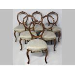 A SET OF SIX VICTORIAN MAHOGANY DINING CHAIRS, the hooped backs with carved floral decoration, the