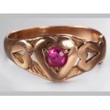 A 9CT ROSE GOLD AND RUBY RING, claw set ruby in heart shape with vertical heart shaped shoulders,