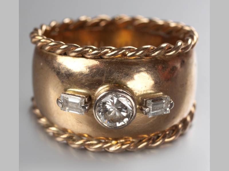 A 9CT YELLOW GOLD AND DIAMOND RING, centre tube set diamond flanked by two baguettes, diamonds of