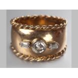 A 9CT YELLOW GOLD AND DIAMOND RING, centre tube set diamond flanked by two baguettes, diamonds of