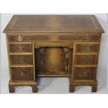 A GEORGIAN STYLE KNEEHOLE DESK, the top with feather banding and a bevelled edge above a single long