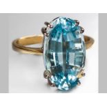 AN 18CT YELLOW GOLD AND BLUE TOPAZ RING, oval topaz claw set, plain shoulders ending on a solid