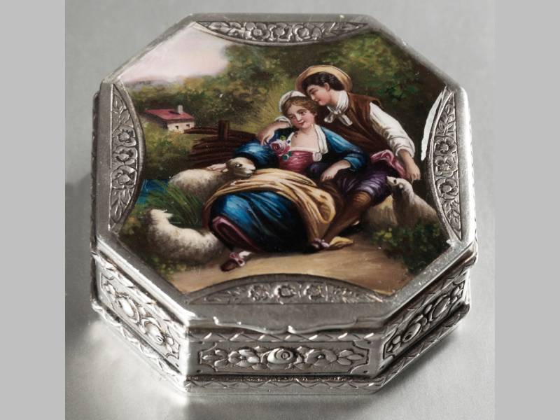 A CONTINENTIAL SILVER AND ENAMEL TRINKET BOX, the hinged top depicting a romantic scene, of