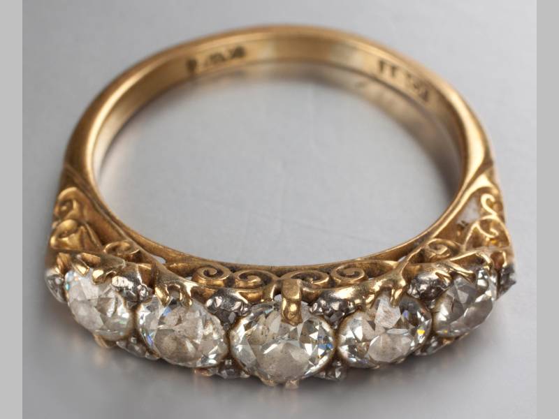 AN 18CT YELLOW GOLD AND DIAMOND RING, five claw-set diamonds of approximately 1.10cts, decorated