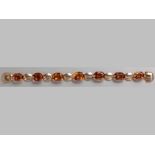 AN 18CT YELLOW GOLD AND CITRINE BRACELET, seven oval citrines claw set interspaced with gold framed,