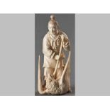 A CHINESE IVORY FIGURE OF A MAN, EARLY 20TH CENTURY, the man subduing a gigantic eagle with his
