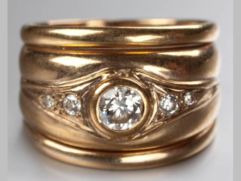 A 9CT YELLOW GOLD AND DIAMOND RING, tube set centre diamond flanked by two claw-set diamonds of