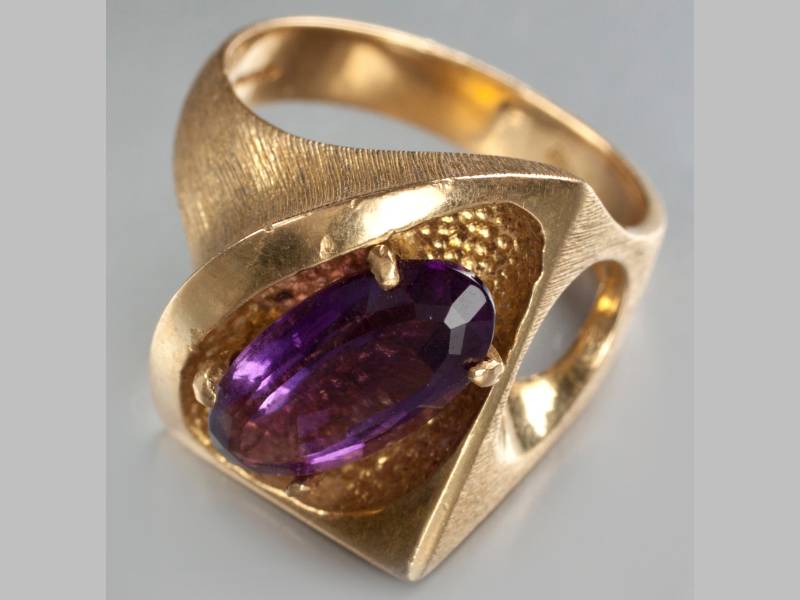 AN 18CT YELLOW GOLD AND AMETHYST RING, with oval amethyst claw-set in an organic form frame, 13g.