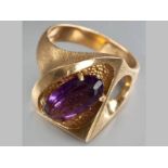 AN 18CT YELLOW GOLD AND AMETHYST RING, with oval amethyst claw-set in an organic form frame, 13g.