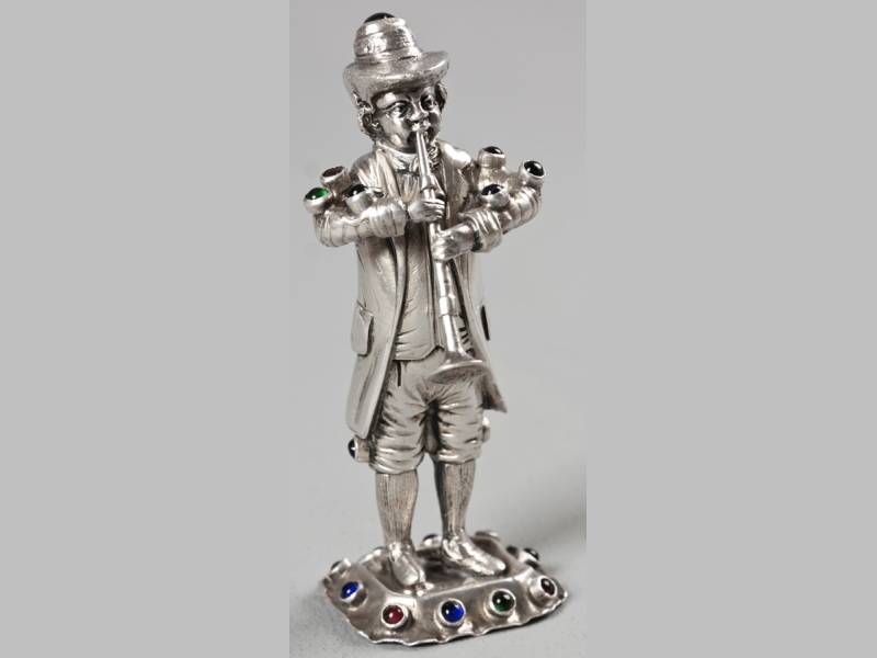 A CONTINENTAL SILVER AND SEMI-PRECIOUS STONE FIGURE OF A TRUMPET PLAYER, 11.5cm high, 109g.