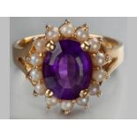 A 14CT YELLOW GOLD, SEED PEARL AND PURPLE STONE CLUSTER RING, centre claw-set stone surrounded by