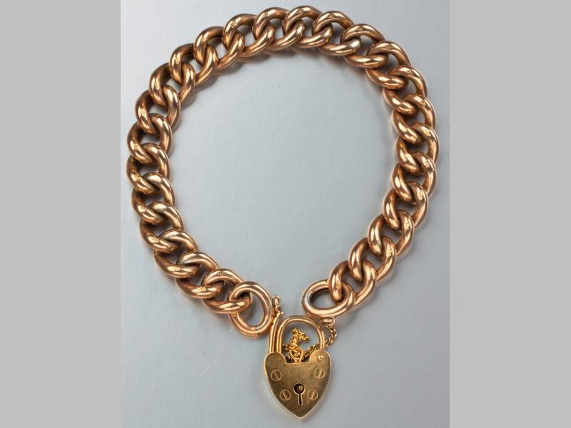 A 9CT YELLOW GOLD BRACELET, with curb links, lock clasp and safety chain, 20cm long, 19.7g.