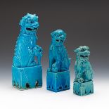 Three Chinese Porcelain Graduated Size Foo Dogs on Pedestals
