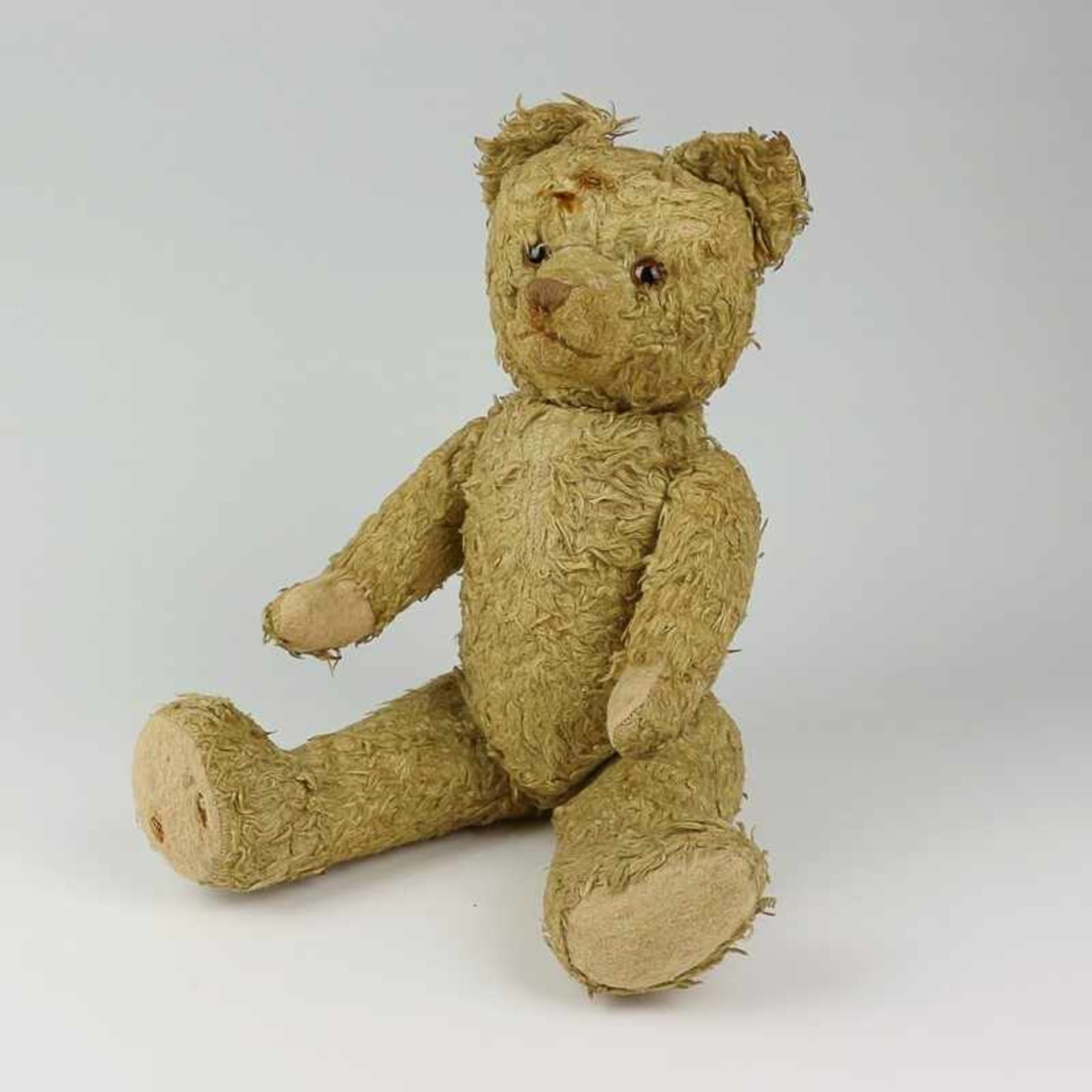 Plüschtier Teddy, um 1910/30, blond, längsgestickte Schnauze, Buckel, besch., stark abgeliebt,