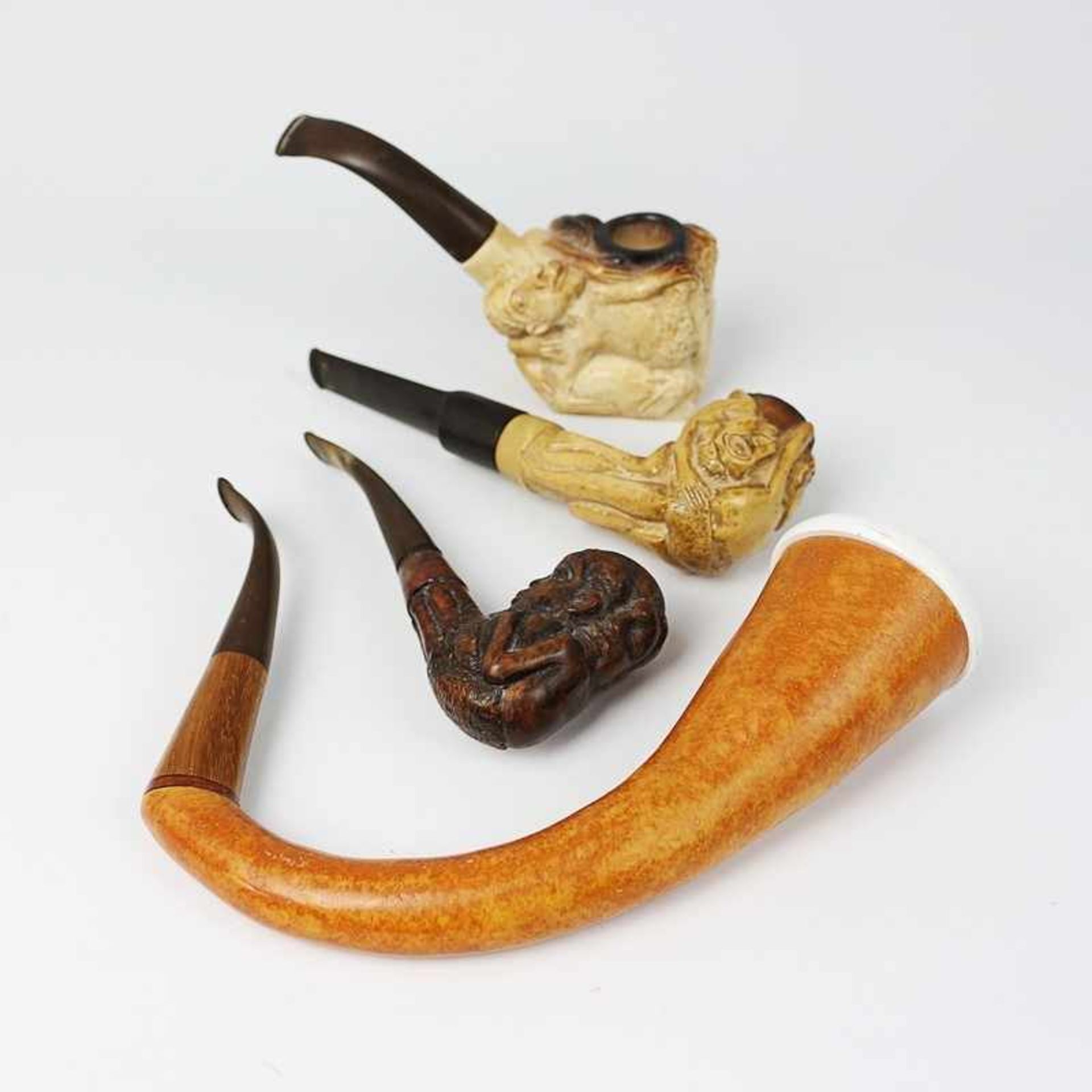 Pfeifen 4 St., 20.Jh., Tansania u.a., Meerschaum, Holz, 3x geschnitzt, figürlicher Dekor, Alterssp.,